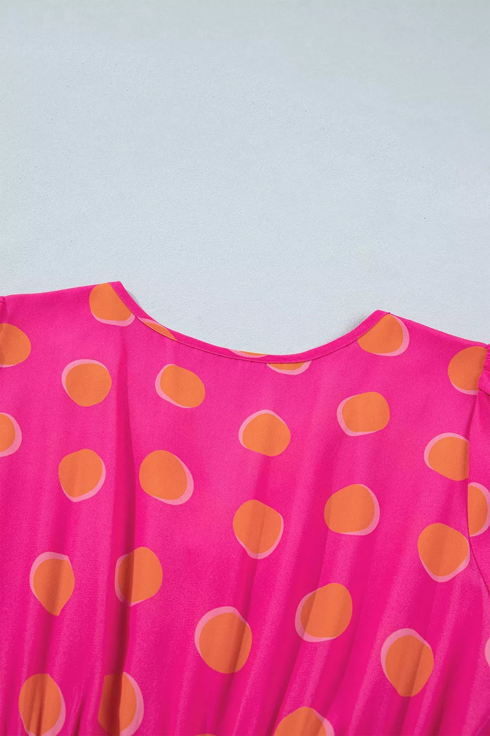 Hot pink polka dot dress neckline with V-cut and gathered yoke