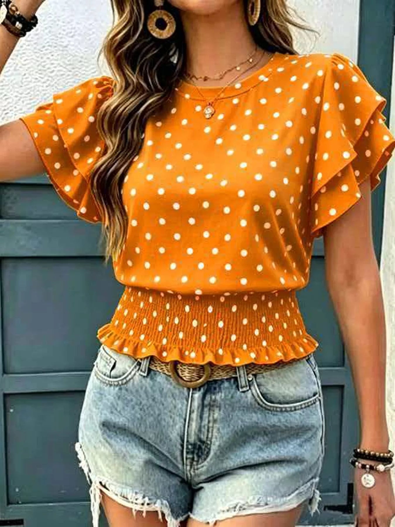 Orange polka dot blouse with flutter ruffle sleeves and gathered peplum