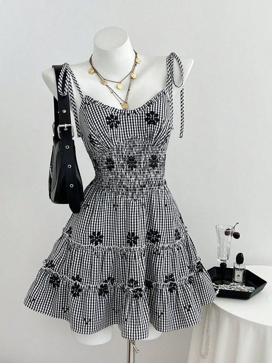 Black gingham tiered mini dress with dark floral appliques and ruched bodice