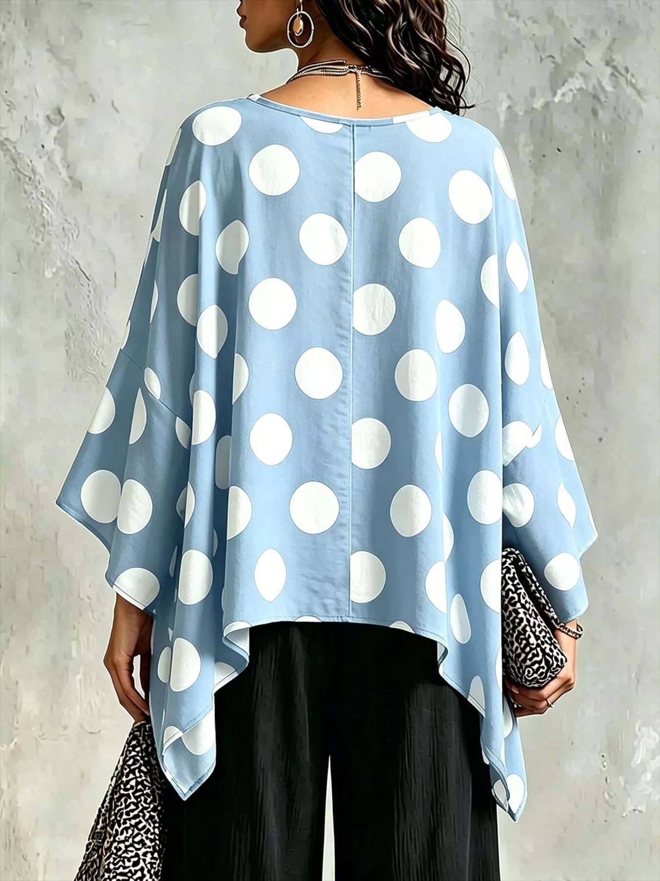 Light blue polka dot asymmetrical hem blouse, back view with draped batwing sleeves.