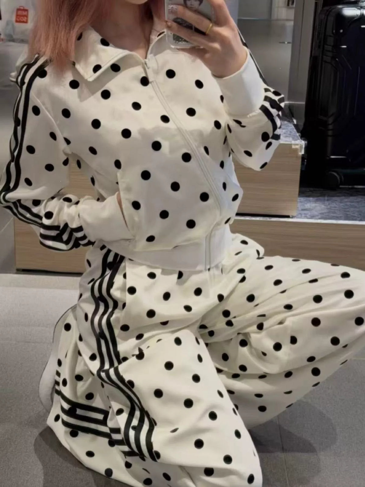 White polka-dot zip jacket with black sleeve stripes and matching pants, cropped view