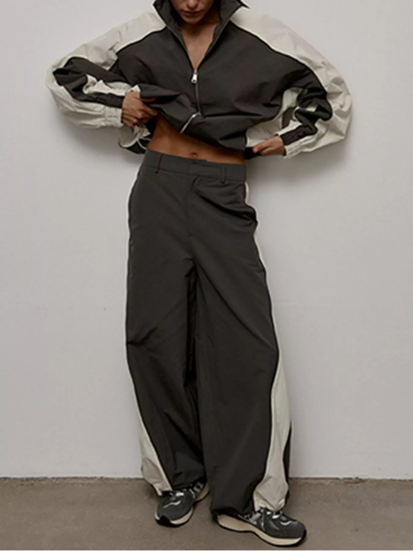 Color-block zip-up jacket and wide-leg pants set in black with light side panels.