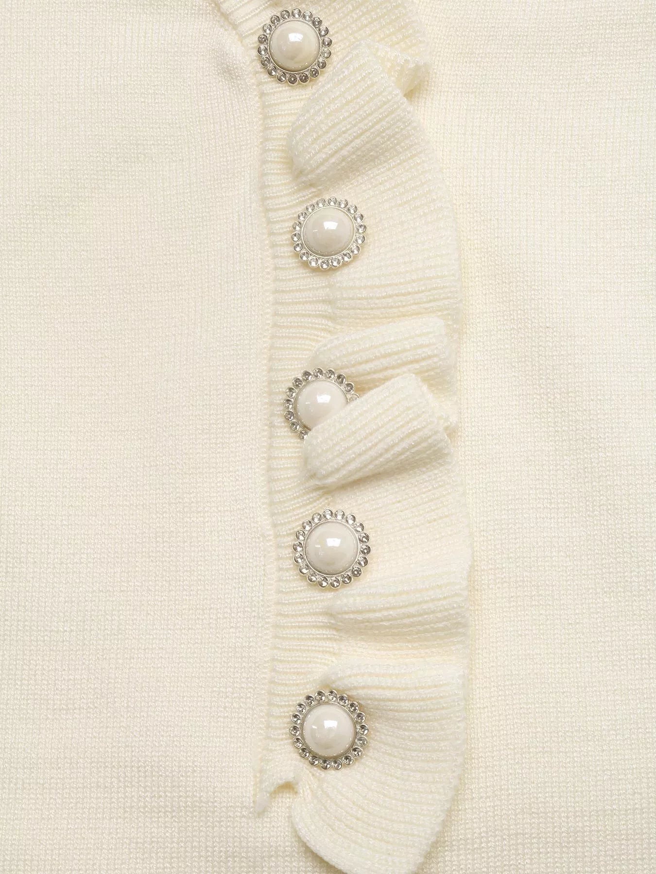 Close-up: Pearl-look button row on cream knit V-neck top