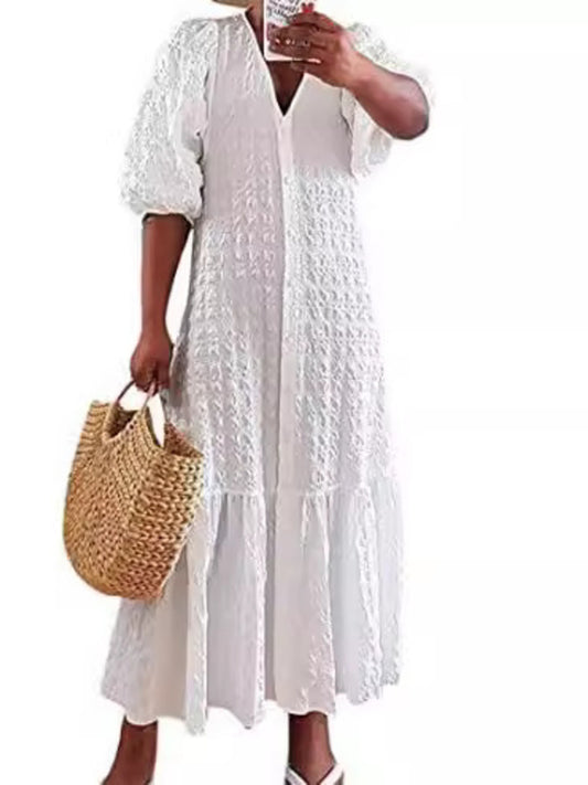 White textured maxi dress with V-neck, puff sleeves, and tiered ruffle hem