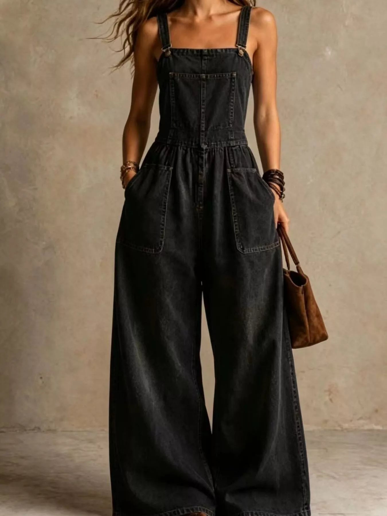 Black denim wide-leg jumpsuit with adjustable straps and front pockets