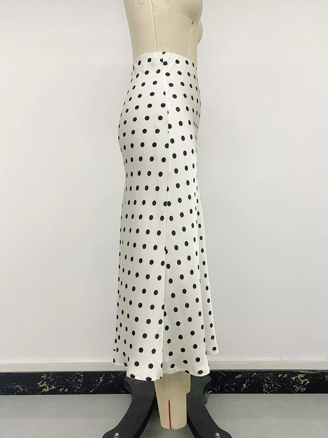 Cream polka dot midi skirt with black dots, mannequin side view showing drape and hem