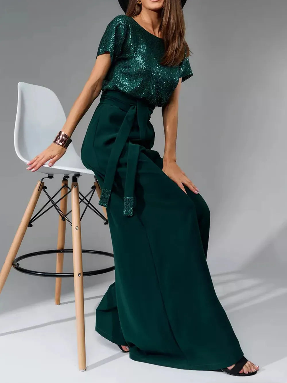 Front view: dark green sequin short-sleeve wide-leg jumpsuit with waist sash