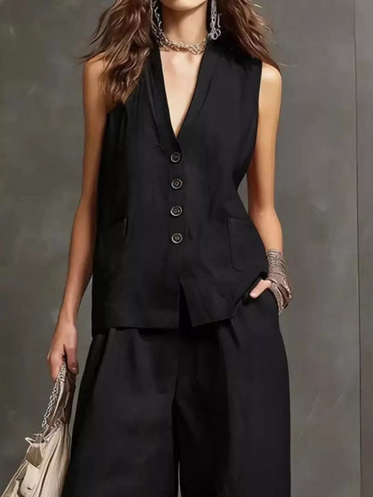 Black sleeveless button-front vest and wide-leg pants set, close-up view