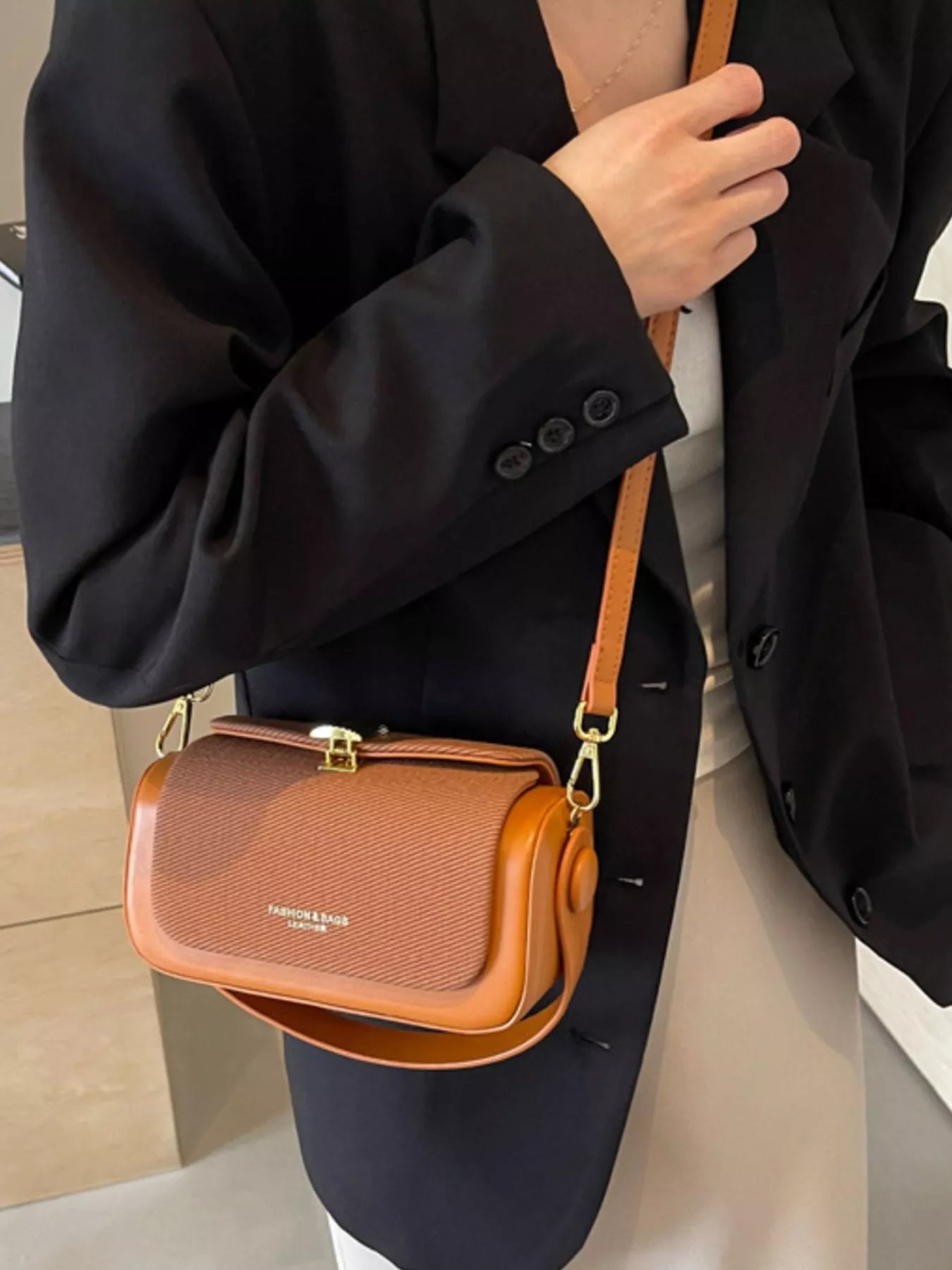 Brown mini crossbody bag with gold-tone clasp and adjustable shoulder strap