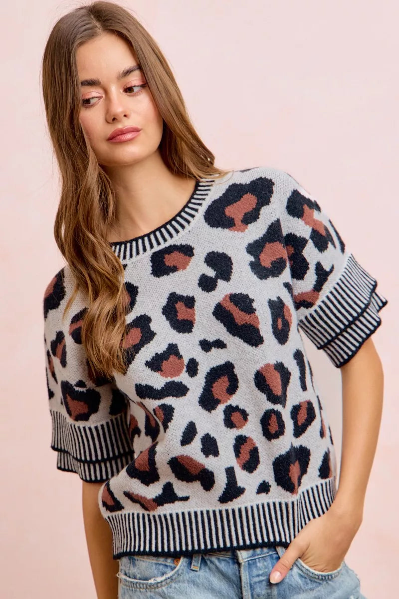 Leopard print knit top with ribbed crew neck and striped sleeve cuffs