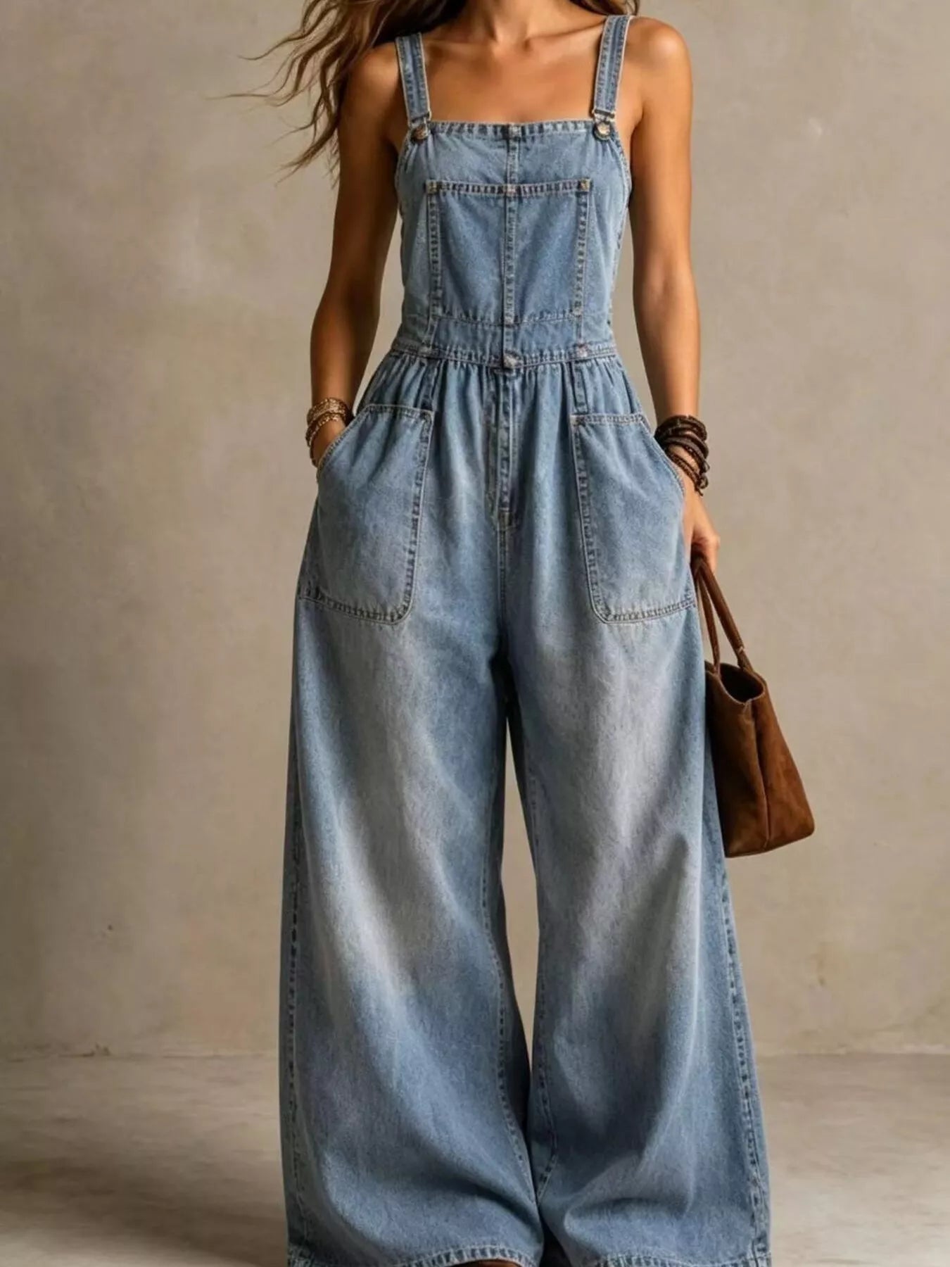 Light blue denim wide-leg jumpsuit with adjustable straps and front pockets