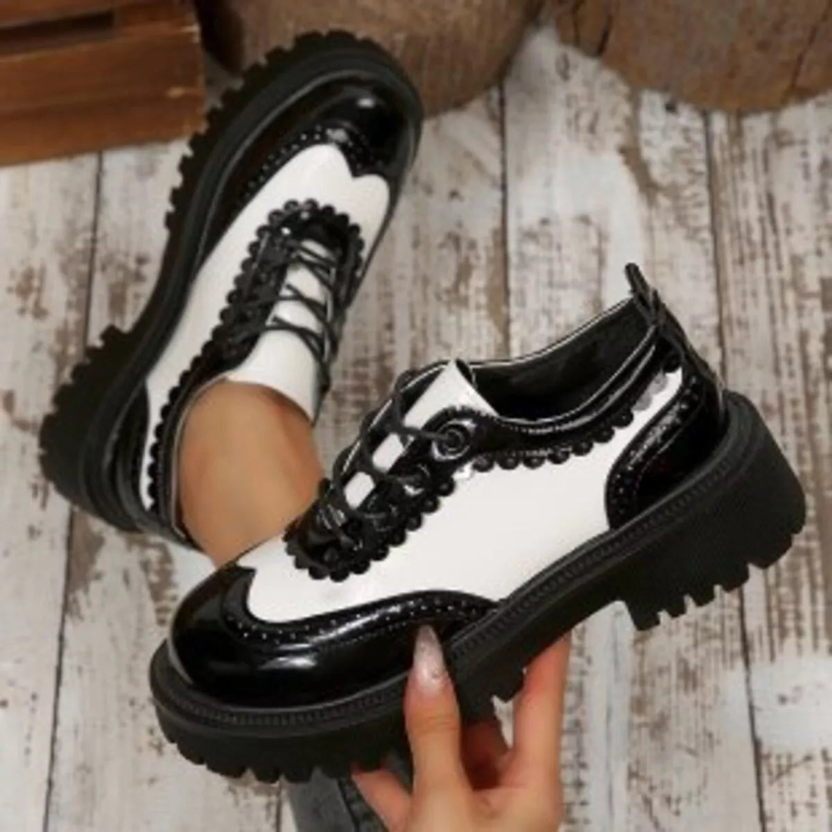 Two-tone platform loafers with white upper, black glossy panels, and chunky tread