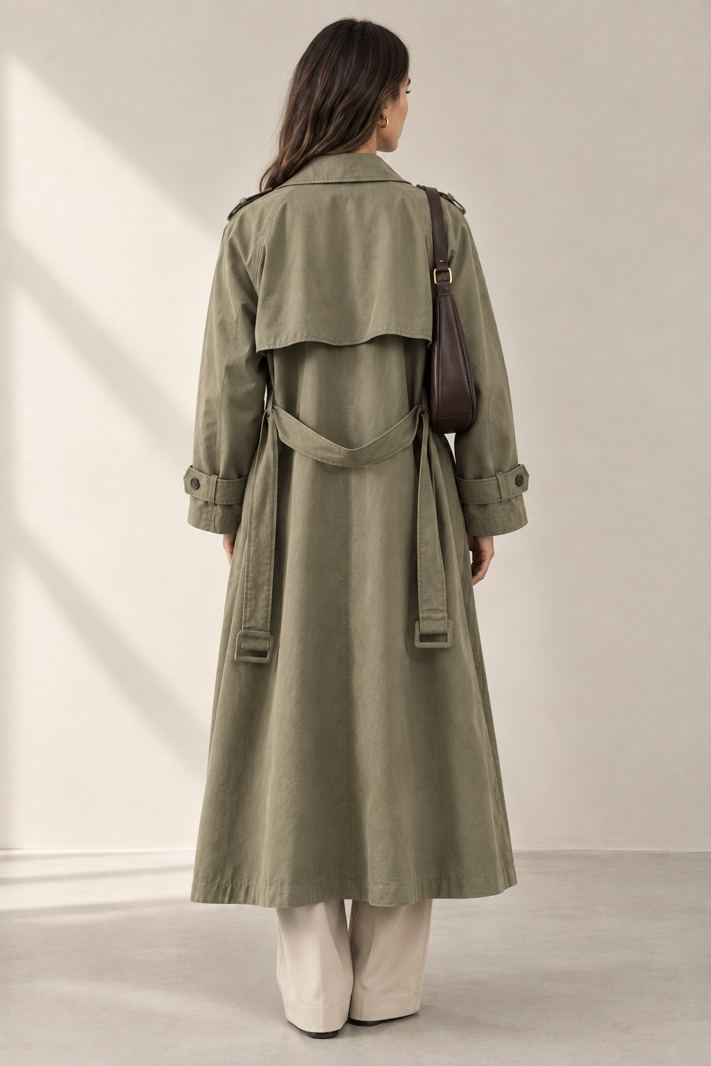 Front view of a women's khaki belted trench coat on a model