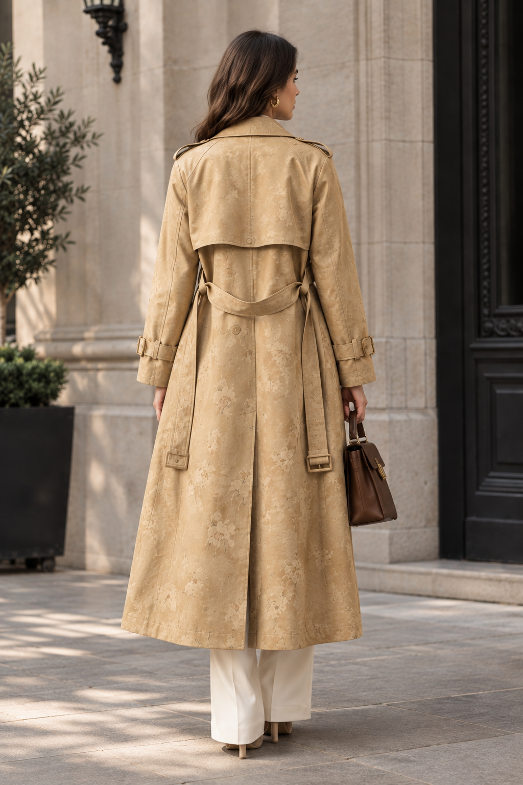 Back view of a model wearing a women's printed patchwork double-breasted belted trench coat