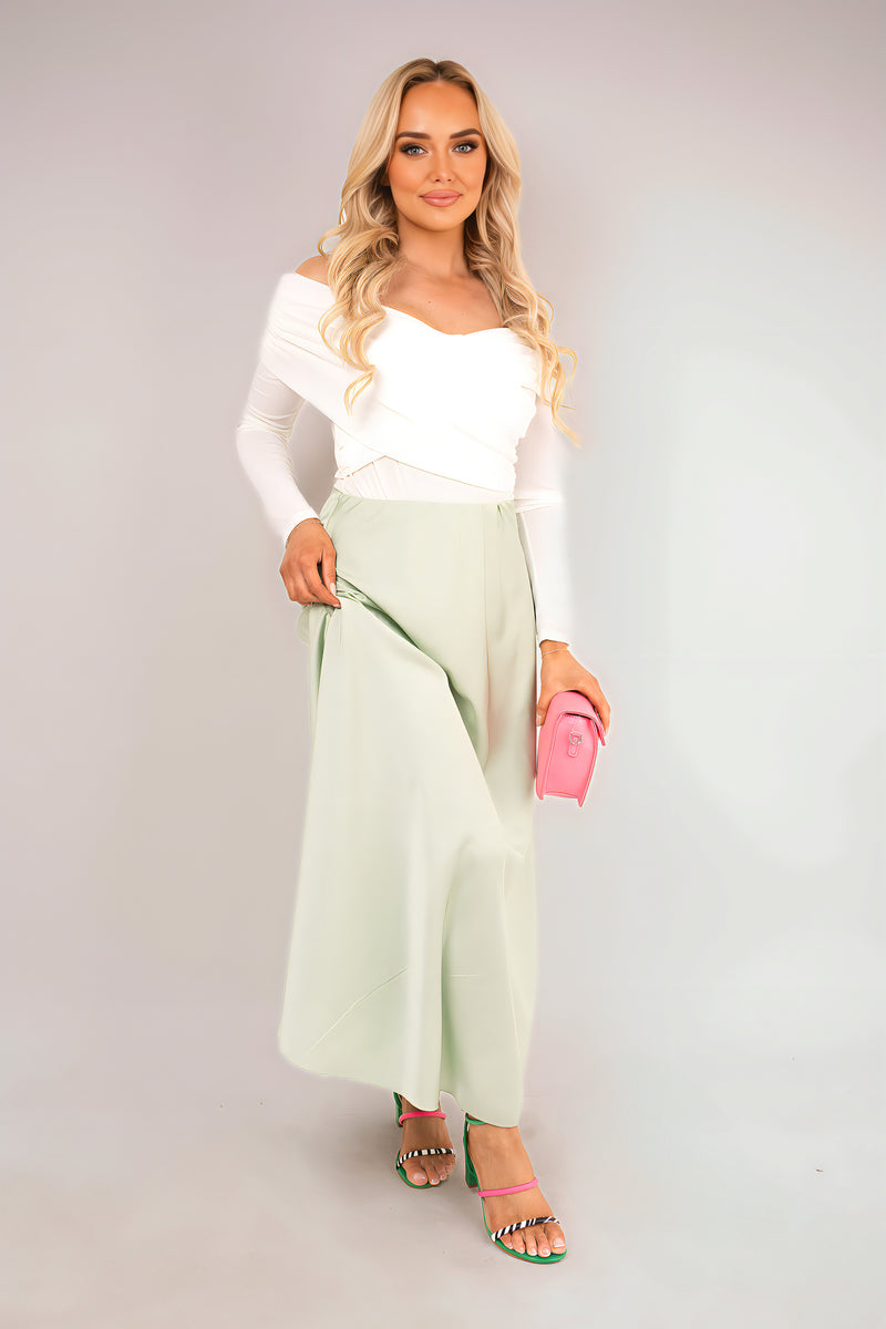 Light green off-shoulder long-sleeve bodysuit with elastic neckline and fitted waist