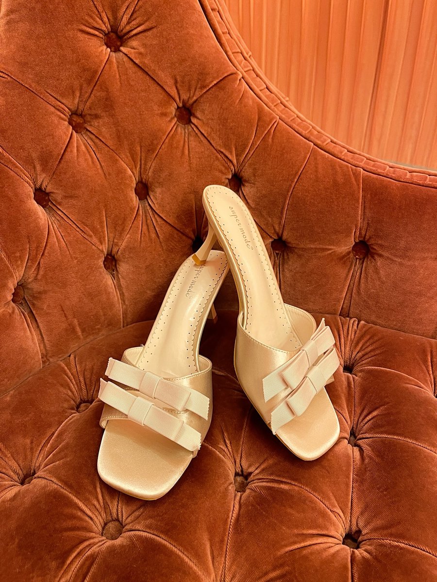 Cream open-toe high heels with bow detail on the front straps