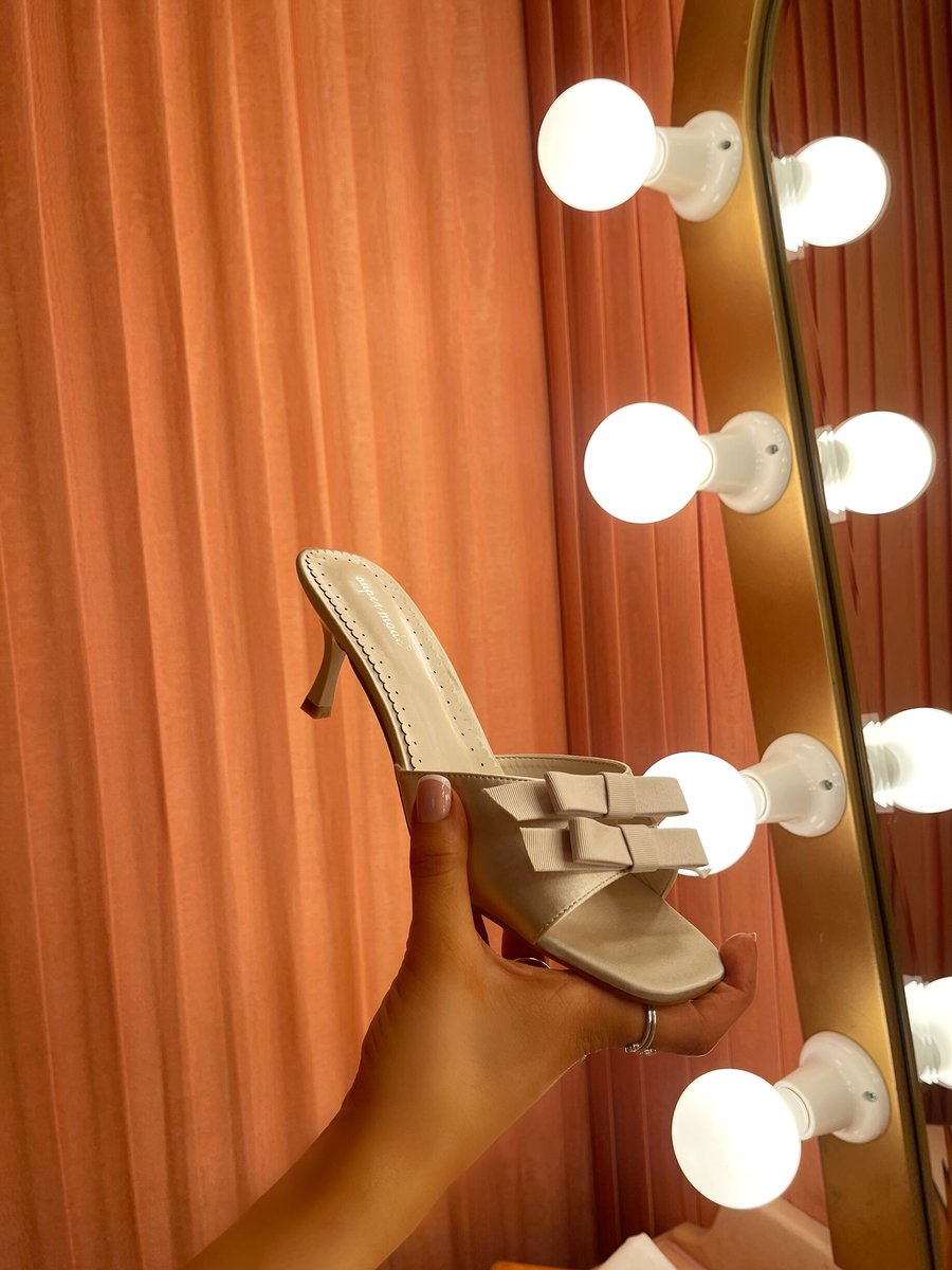 Cream open-toe high heel sandals with front bow detail, side view