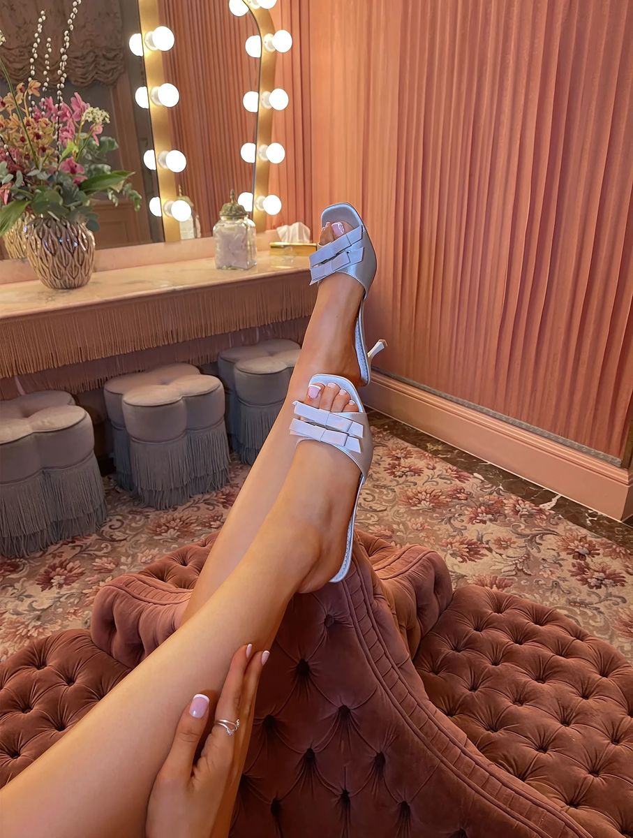 Open-toe high heel sandals with front bow detail, shown on model