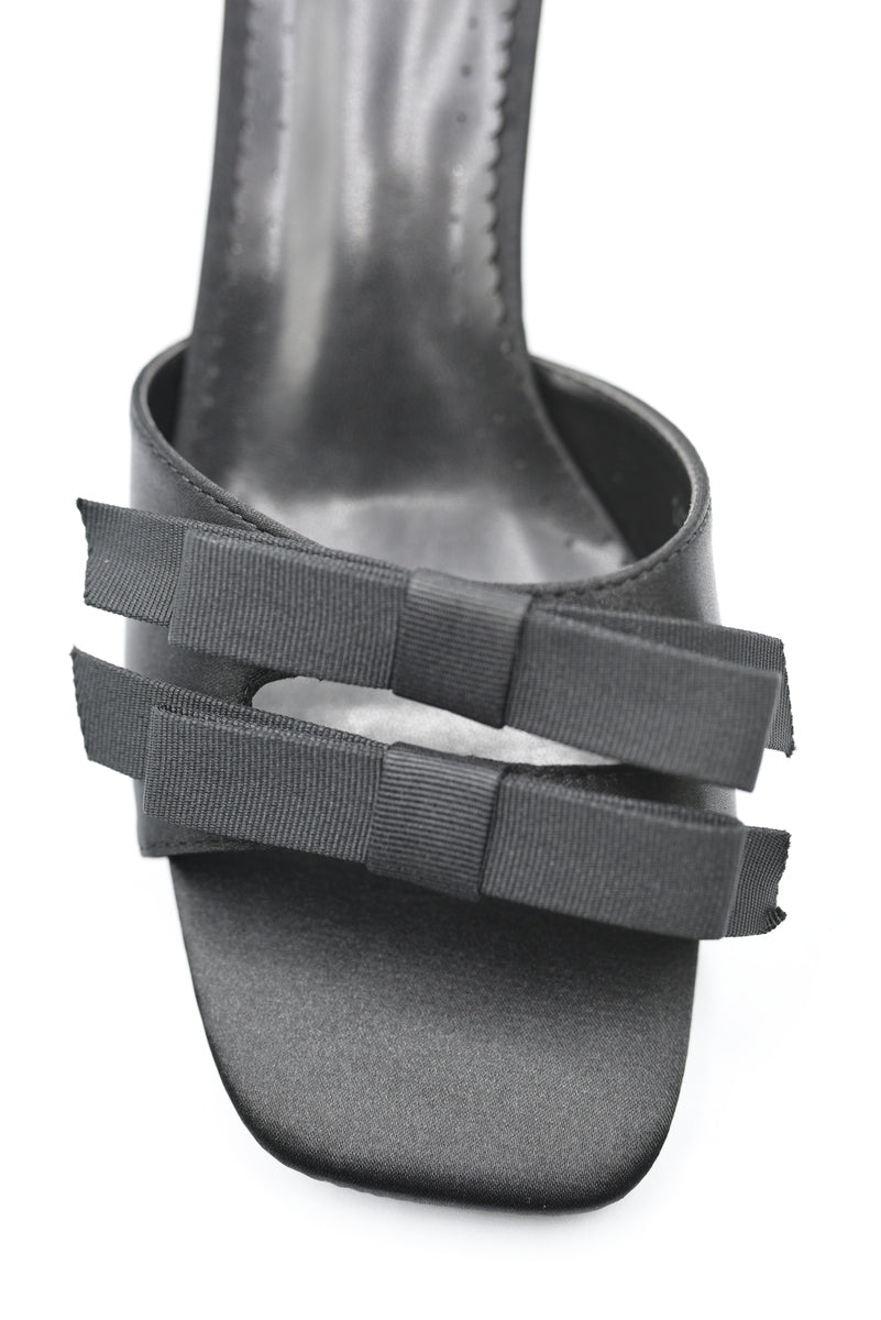 Black open-toe mule heel with bow-like ribbon detail on the front strap