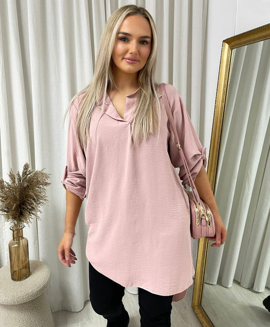 Loose-fit tunic top in pink with rolled sleeves and front button placket