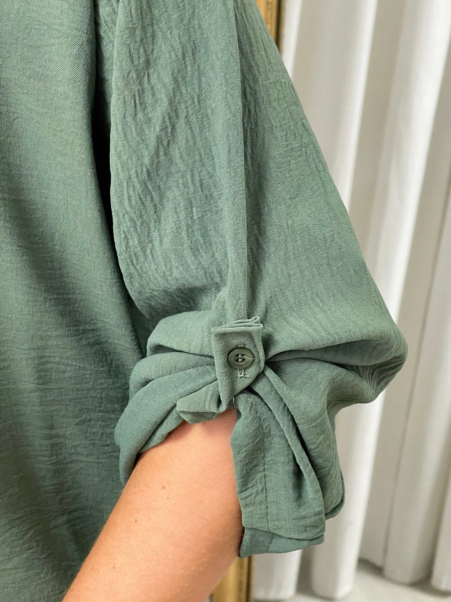 Dark green tunic sleeve cuff with tied knot detail