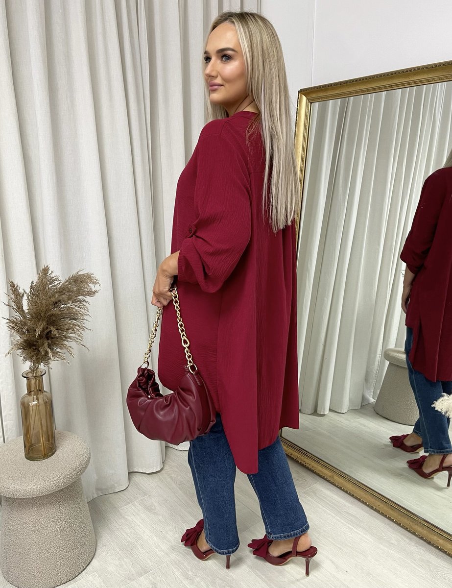 Loose-fit long-sleeve top in wine red with roll-up sleeves, shown in side view