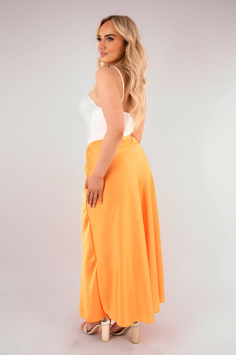 High waisted maxi skirt in lightweight orange, side view with pleated look and long hem