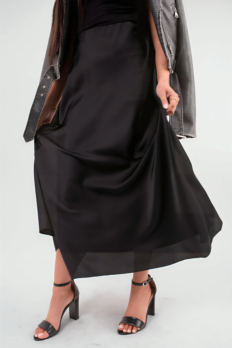 Black high-waisted maxi skirt with side drape and flowing, full-length skirt