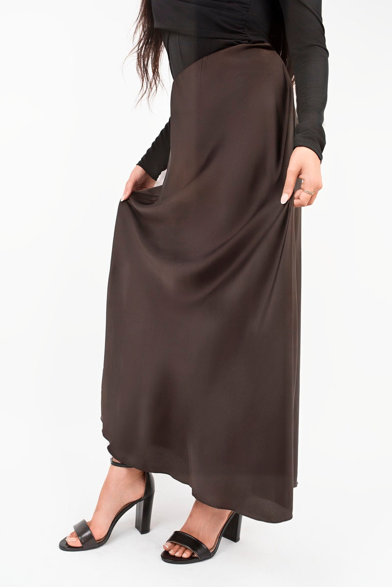 Close view of chocolate-brown high-waisted maxi skirt with smooth, flowing fabric