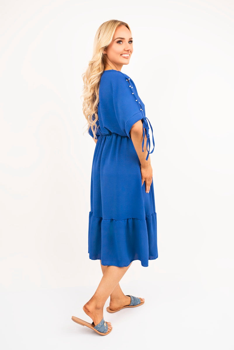 Royal blue round-neck midi dress with tie sleeves and tiered ruffle hem, side view