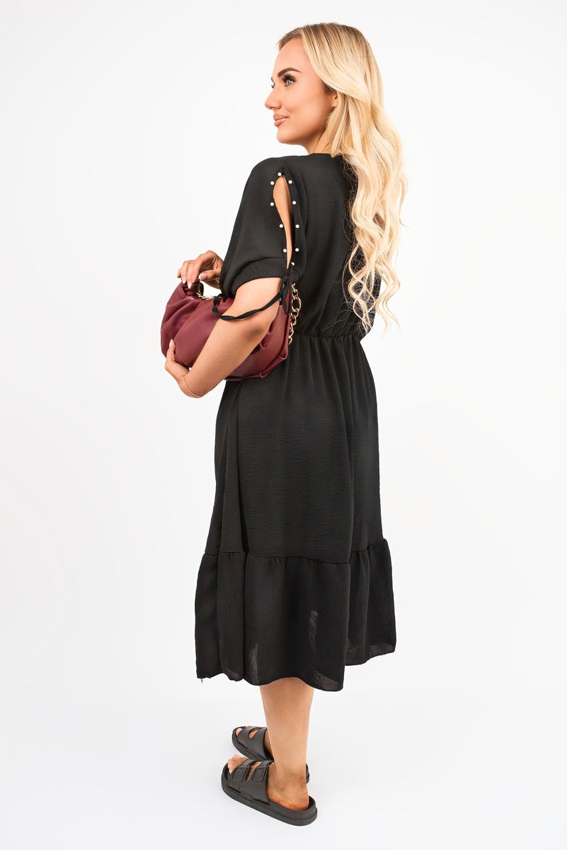 Black round neck midi dress, back view with tie sleeve details and tiered hem