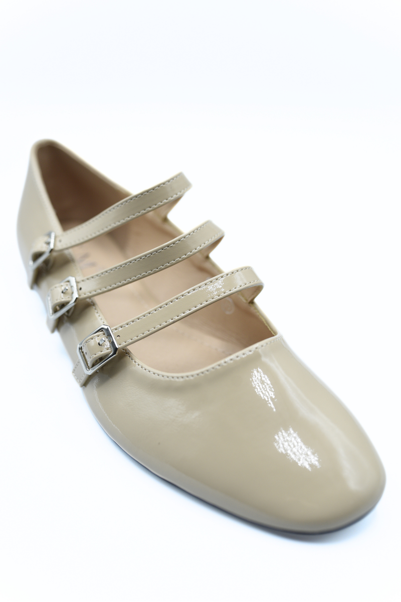 Beige strappy flat shoes close-up with three buckle straps and smooth finish