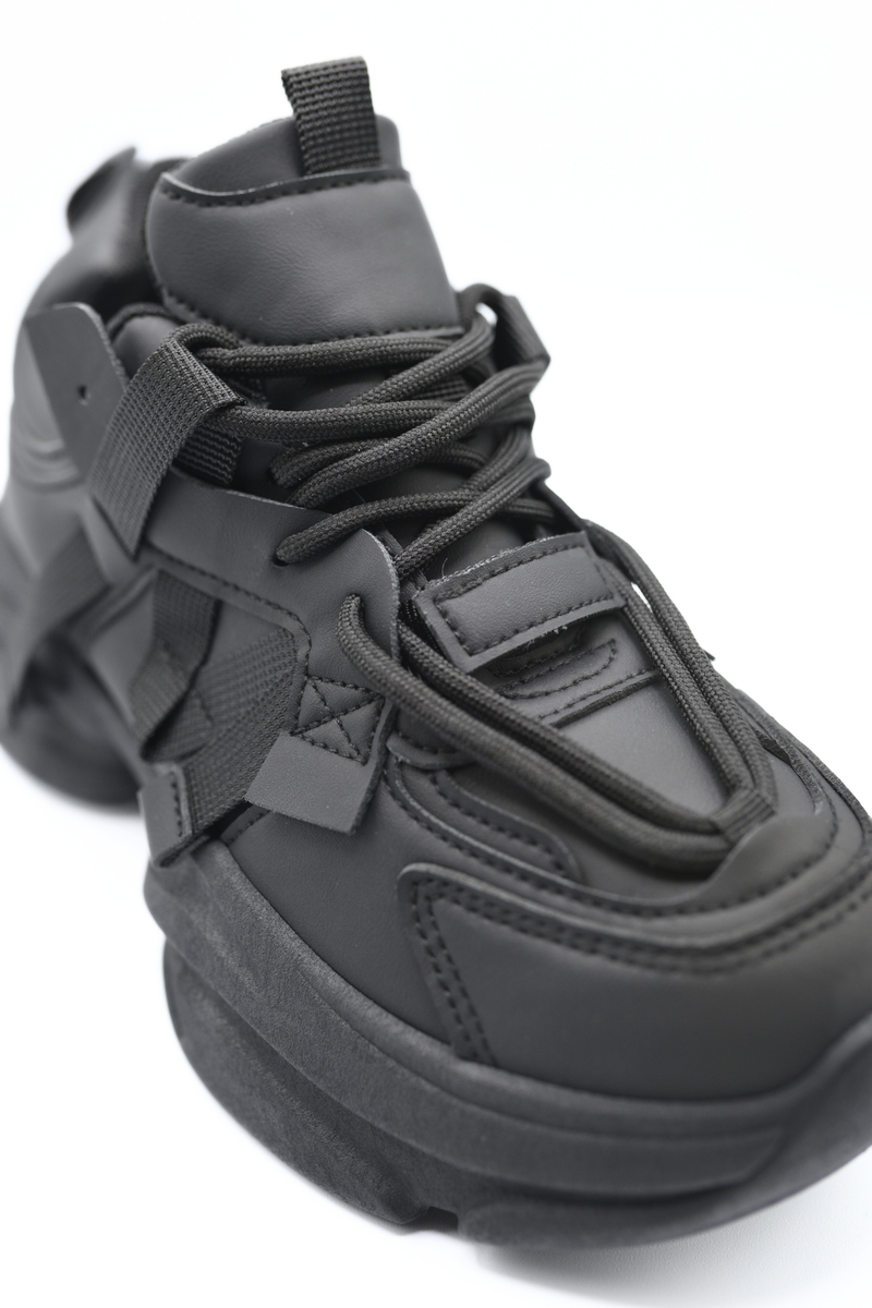Black lace-up chunky trainer with padded tongue, buckled strap, and textured upper