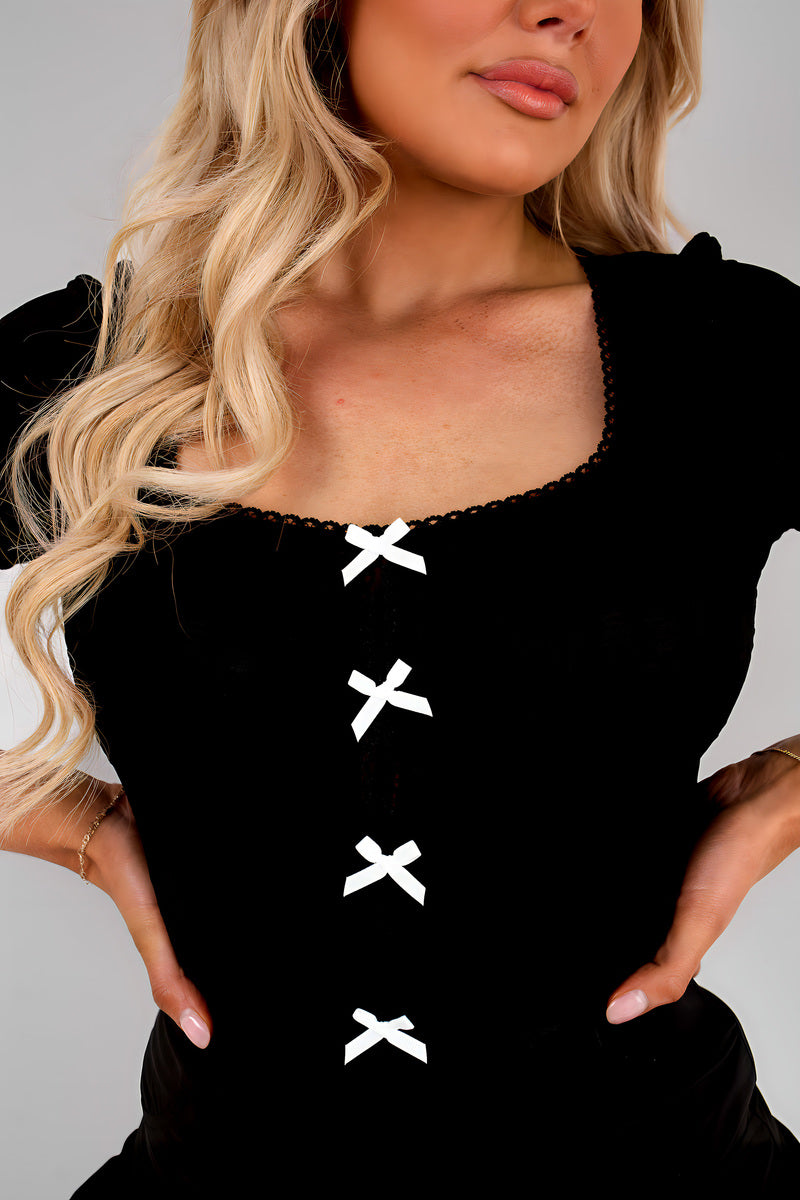 Black square-neck top with short sleeves, front bow and X embroidery detail
