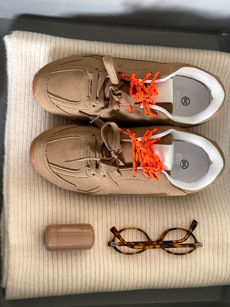 Camel lace-up flat trainers with orange laces, viewed from above