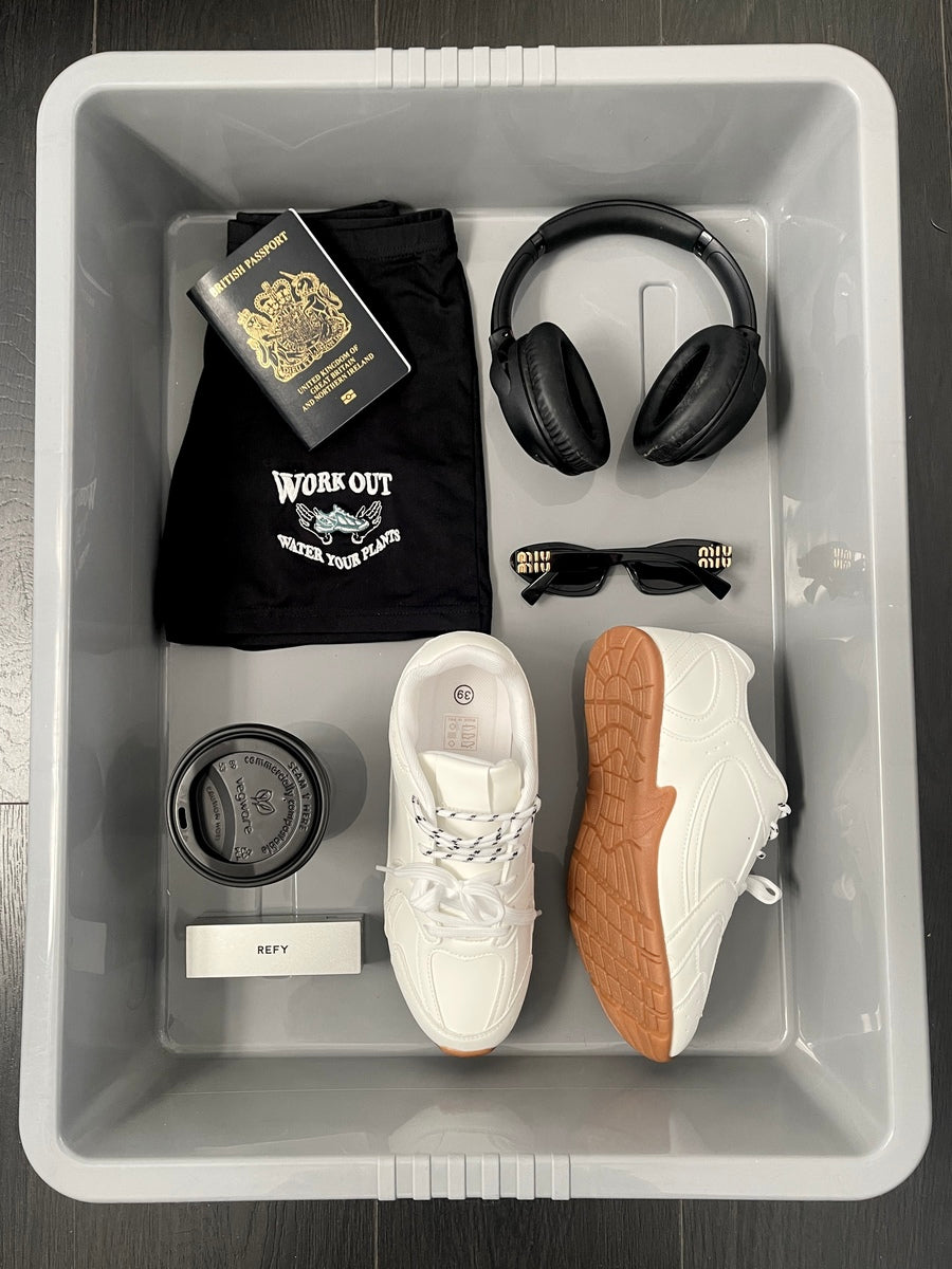White lace-up flat trainers with tan rubber soles and quilted side panel detail.