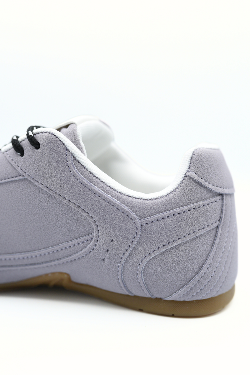 Grey-lilac lace-up flat trainers close-up with textured side panel and white laces