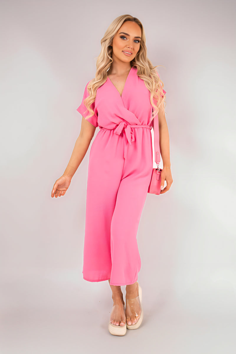 Pink wrap short-sleeve wide-leg jumpsuit with tie waist, front view.
