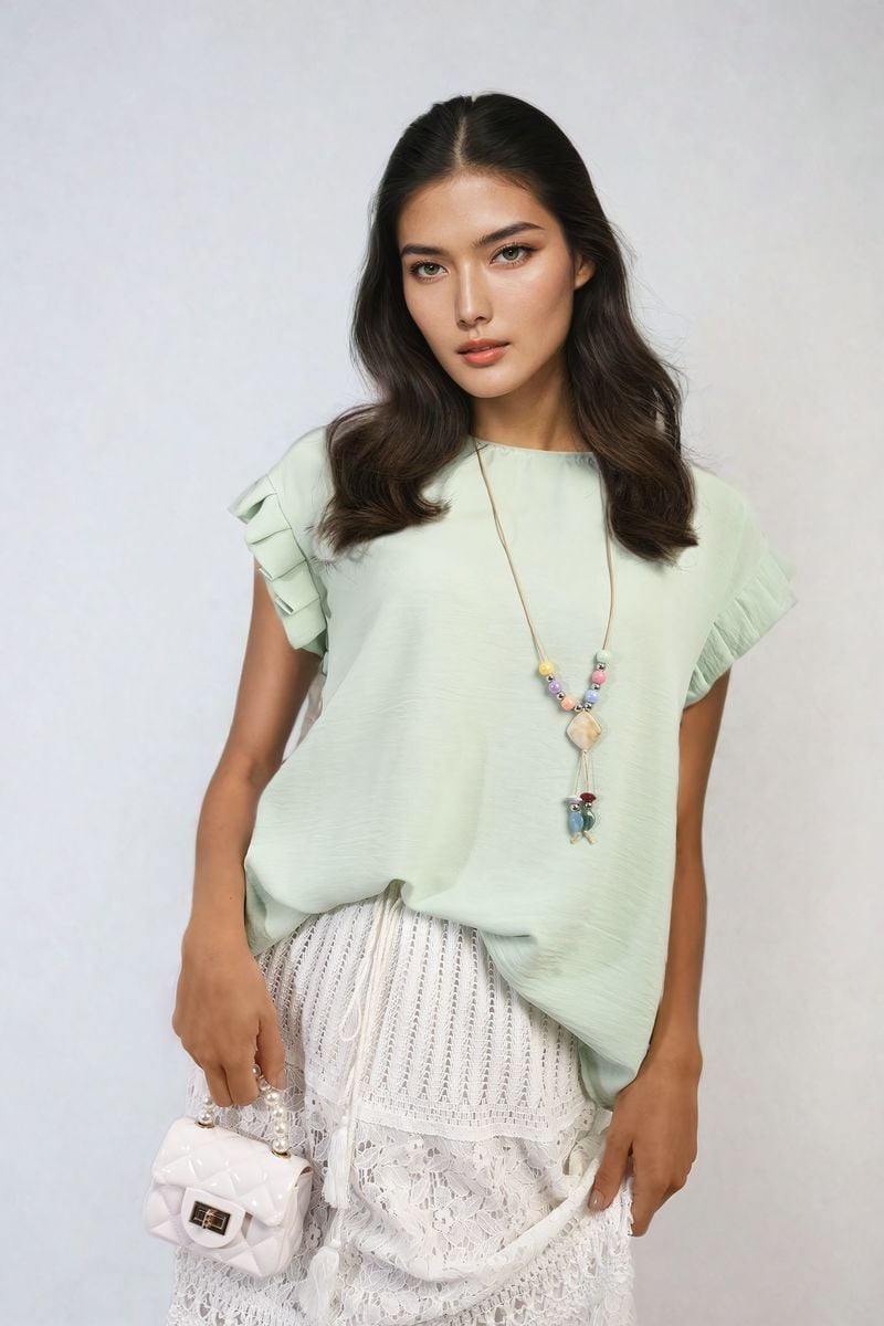 Mint green ruffle-trim sleeve top with round neckline and layered cap sleeves