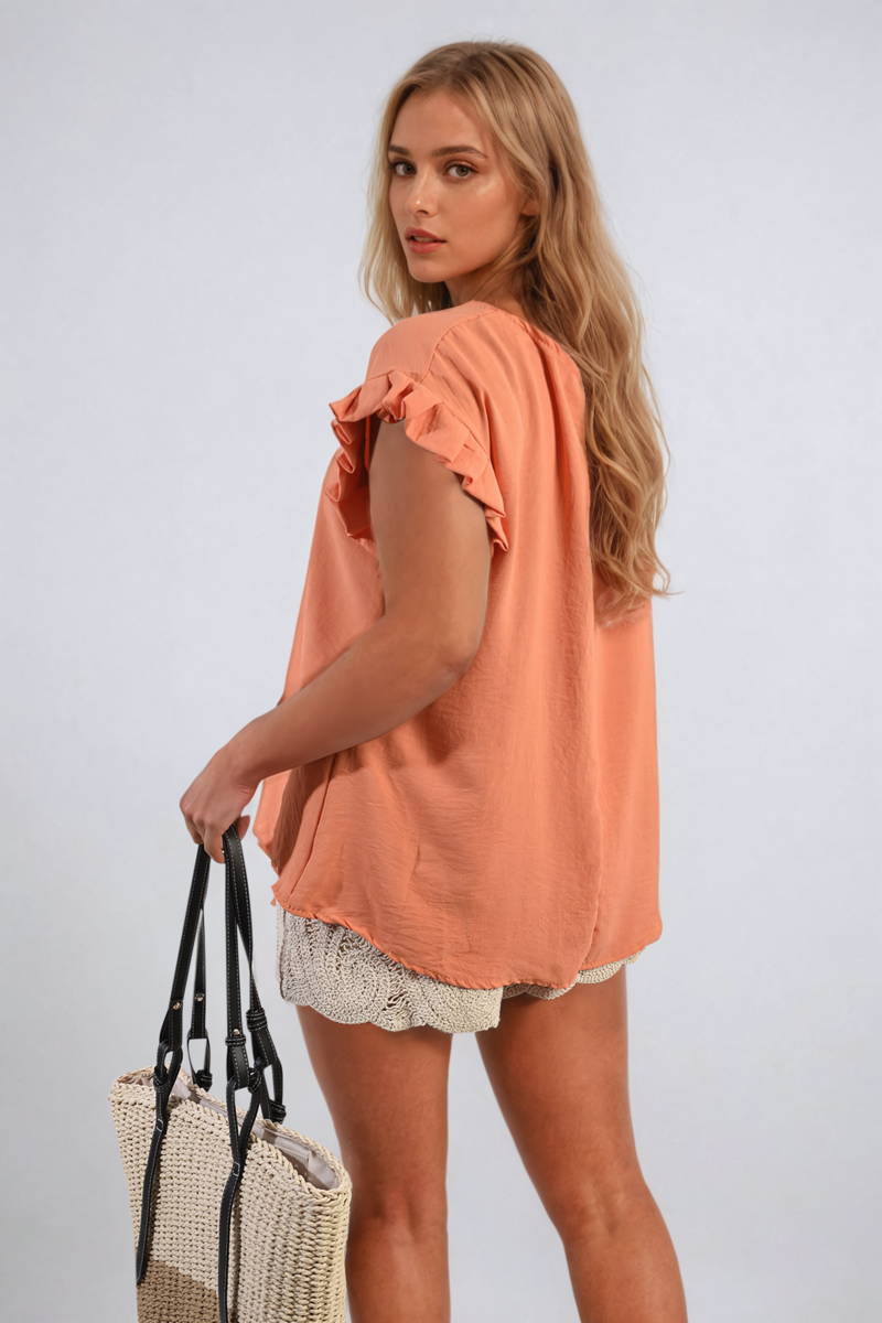 Coral ruffle-trim sleeve top with loose fit and scalloped hemline, crew neckline.