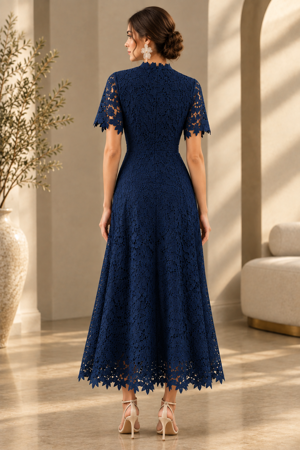 Three-quarter rear view of the navy floral embroidered lace dress, showing the short scalloped sleeves, fitted waist and full scalloped skirt.